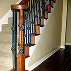 Photograph of straight staircase with a wood newel and metal balusters