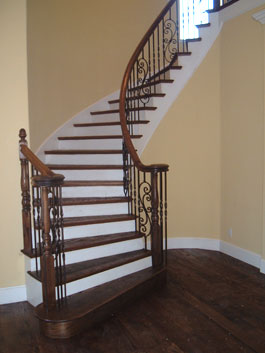 Circular wood staircase with iron balusters