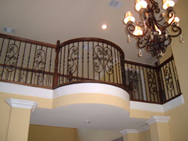 Curved second level landing with wooden handrail and iron balusters