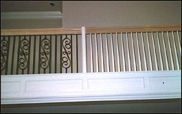 Photo of stair with half wooden balusters and half wrought iron balusters